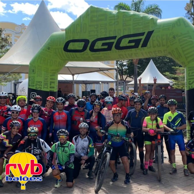 Ciclistas pousando para foto no portal inflável para linha de chegada e largada