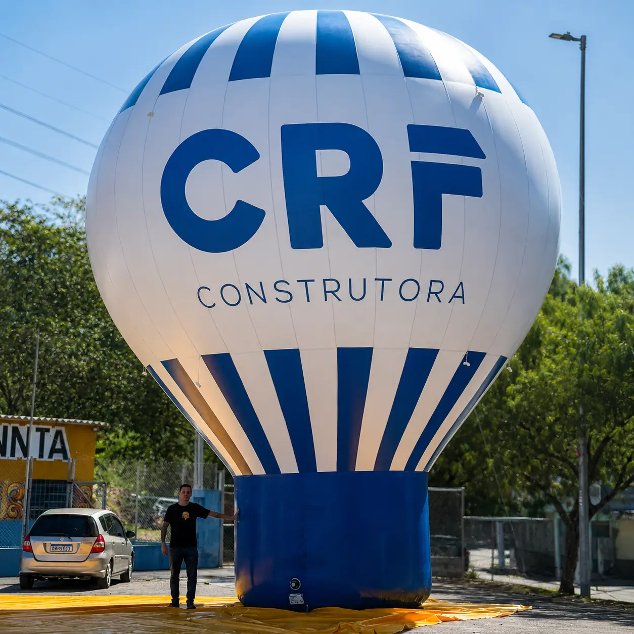 Balão inflável gigante CRF Construtora de 10 metros em escala real mostrando a presença monumental do equipamento RVB Balões com dois motores Ibram embutidos e sistema duplo de desinflagem rápida para segurança operacional