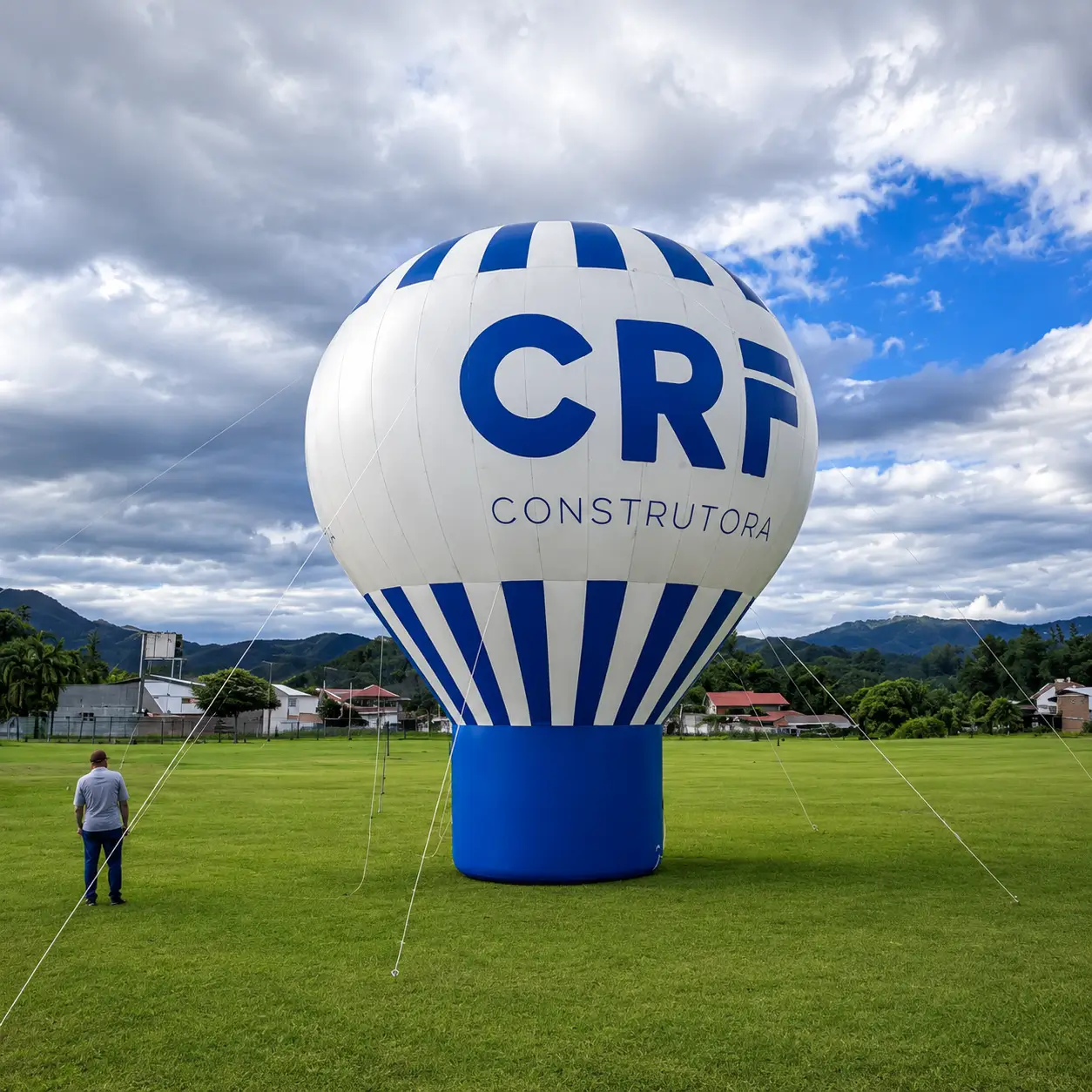 Balão inflável gigante de 10 metros da CRF Construtora instalado em campo aberto durante lançamento imobiliário Baden Residence, fabricado pela RVB Balões com corpo em Têxtil Omborgo 301 Digital e base reforçada em Sansuy SANPRO III com cintas de 600 kg