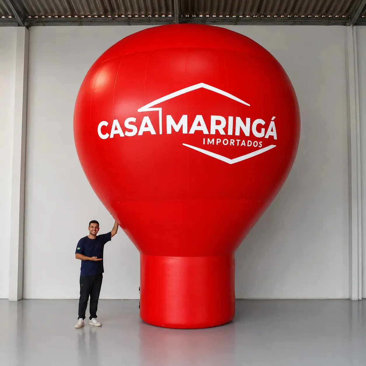 Balão promocional inflável gigante de 6 metros personalizado para a Casa Maringá Importados, produzido pela RVB Balões com identidade visual da marca em Pantone exato, instalado para ampliar visibilidade da loja a longa distância