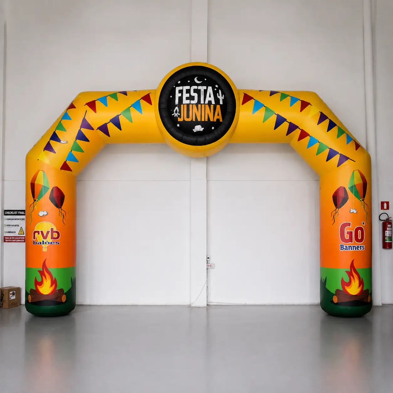 Portal Inflável para Festa Junina — Entrada Personalizada de Arraiá | RVB Balões Portal inflável personalizado da RVB Balões usado como entrada de festa junina, com banner colorido em parceria com Gobanners, instalado em ativação de arraiá empresarial
