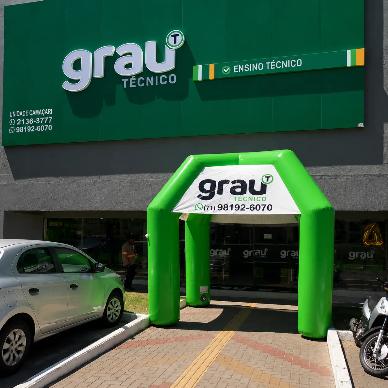 Tenda inflável Grau Técnico — reforço visual na fachada para captação | RVB Balões Tenda inflável verde personalizada Grau Técnico instalada na fachada da unidade para captação de alunos, produzida pela RVB Balões