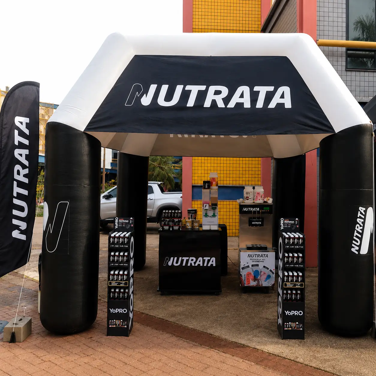 Tenda Inflável Nutrata — Ativação PDV RVB Tenda inflável personalizada Nutrata em ativação de marca de suplementos esportivos, com wind banner lateral, displays YoPRO e estrutura de PDV completa produzida pela RVB Balões