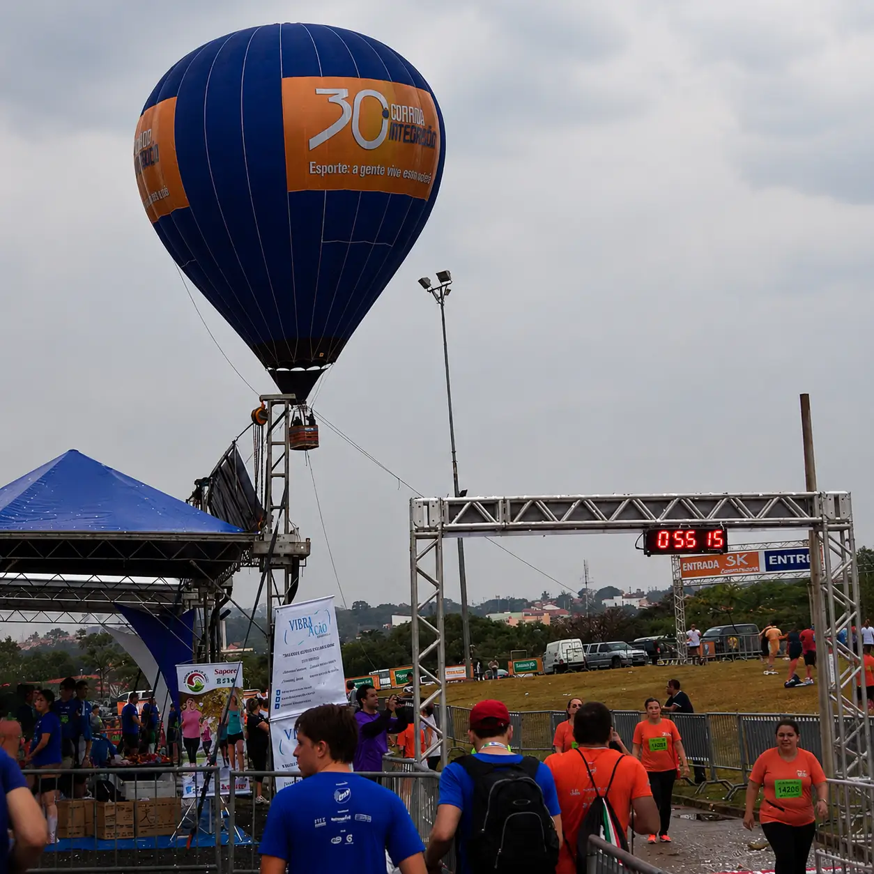 Voo Cativo com Balão Personalizado Corrida Integração — Patrocínio Esportivo e Visibilidade de Marca | RVB Balões Voo cativo com balão de ar quente personalizado da 30ª Corrida Integração em patrocínio esportivo de massa, com público no entorno da chegada, operação RVB Balões