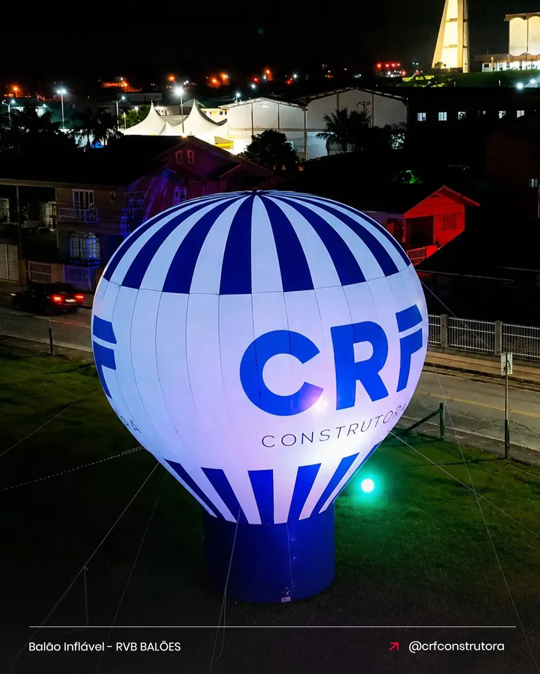 Balão inflável CRF Construtora para o setor imobiliário iluminado à noite em frente ao empreendimento