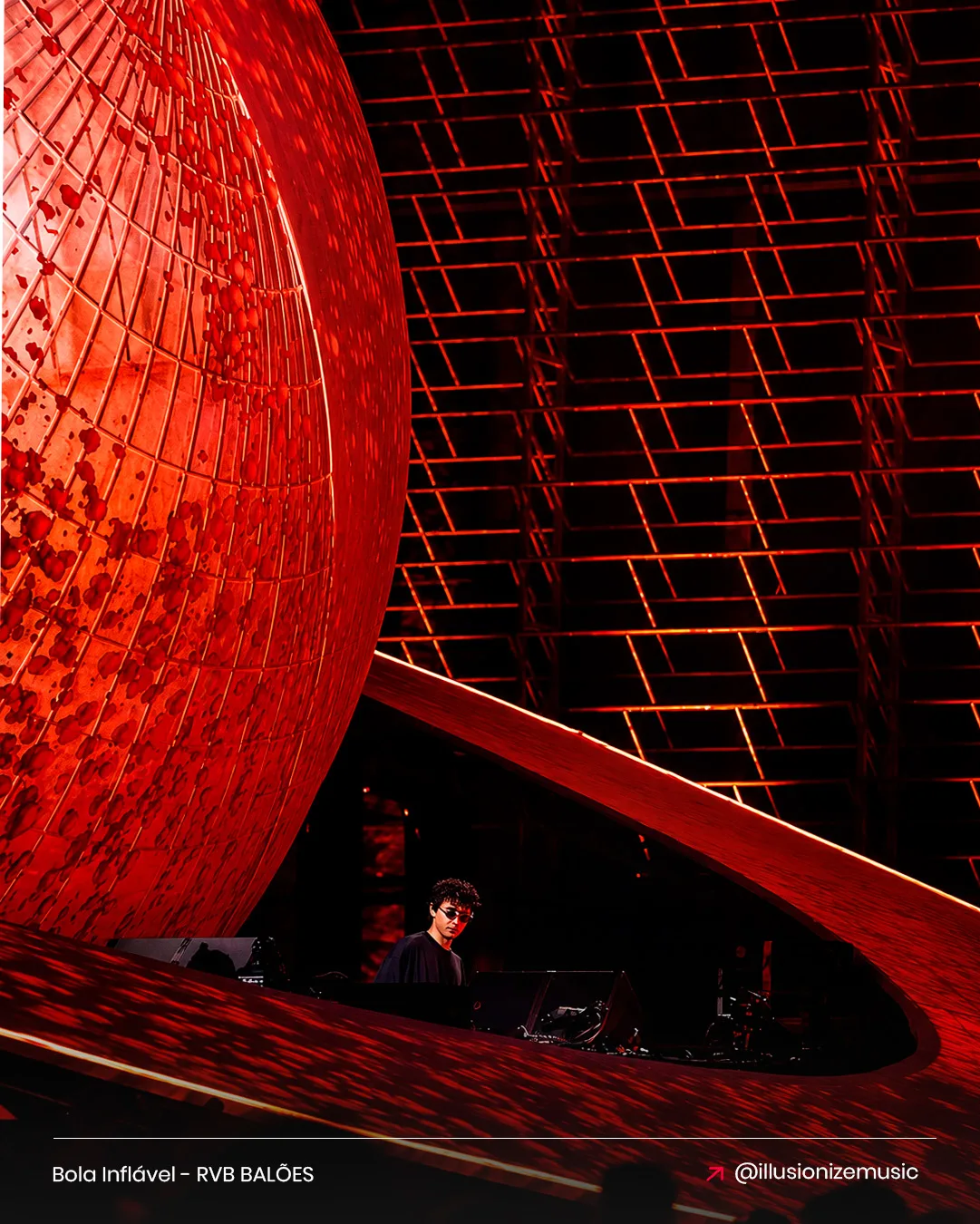 Bola inflável gigante Illusionize em vermelho com o DJ ao centro no show de música eletrônica