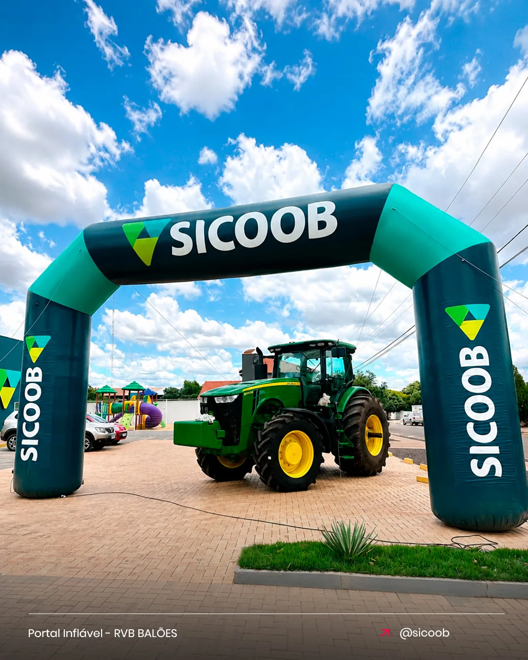 Portal inflável Sicoob para cooperativa de crédito em evento institucional com trator no pátio