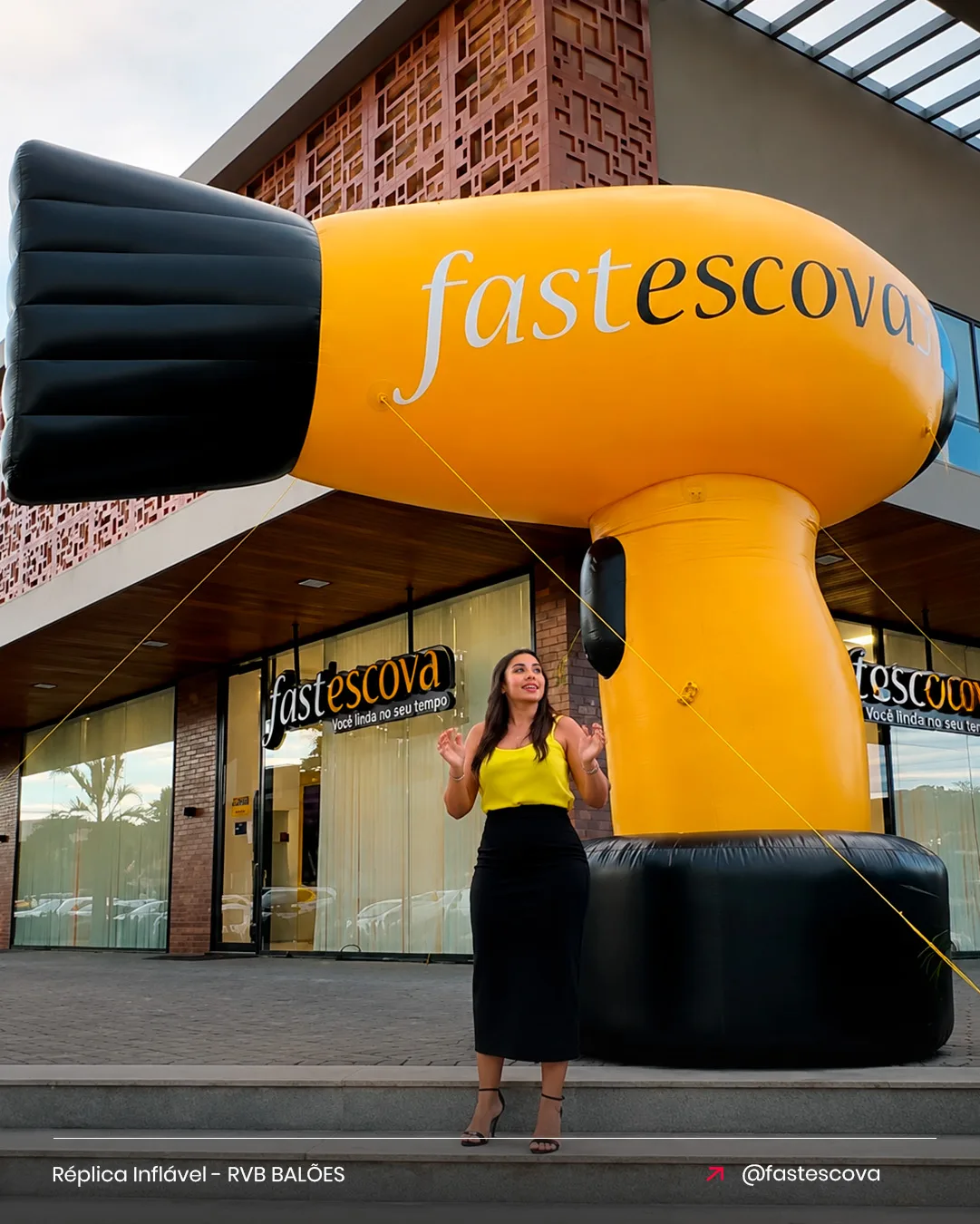 Réplica inflável de secador fastescova para beleza em destaque na fachada do salão ao entardecer