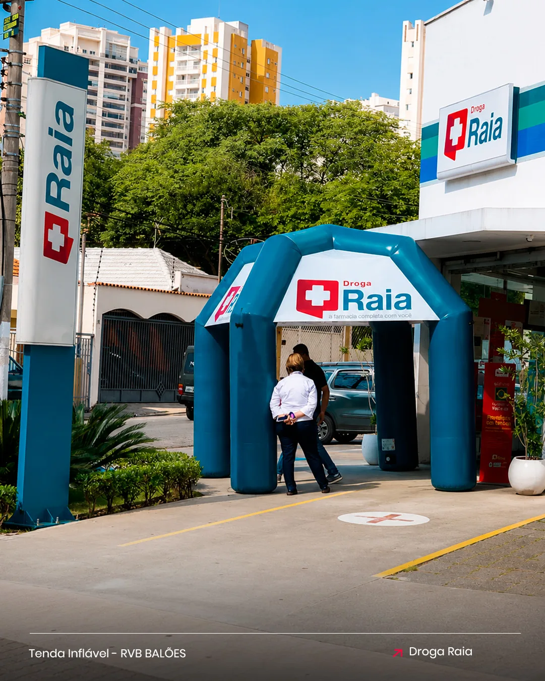 Tenda inflável Droga Raia para farmácia em ação de marketing na entrada da loja com clientes