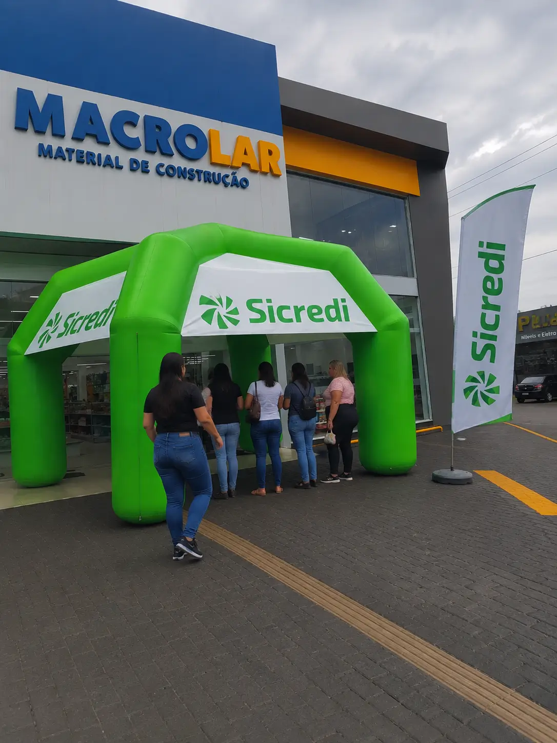 Tenda Inflável Sicredi na Inauguração de Agência | RVB Balões Tenda inflável personalizada Sicredi verde instalada na fachada de agência cooperativa em dia de inauguração, fabricada pela RVB Balões