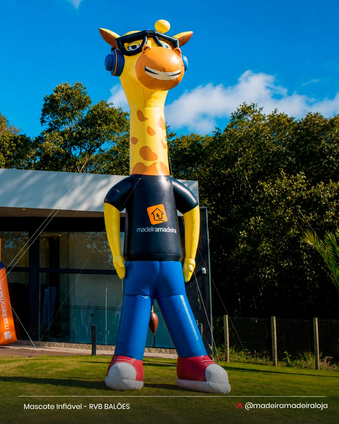 Mascote inflável gigante em formato de girafa personalizado para a MadeiraMadeira instalado em frente à empresa.