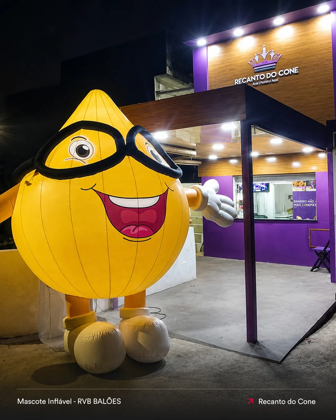 Mascote inflável em formato de cone instalado na fachada do Recanto do Cone para atrair clientes e destacar a loja durante a noite.