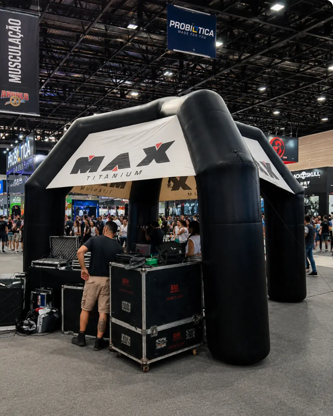 Tenda inflável personalizada da Max Titanium utilizada como estande promocional em feira de negócios, criando um espaço de atendimento e ativação de marca para visitantes.