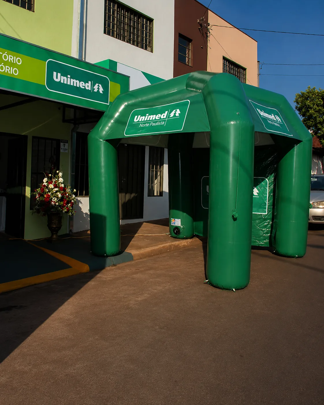 Tenda inflável personalizada da Unimed instalada na entrada de uma unidade de atendimento.
