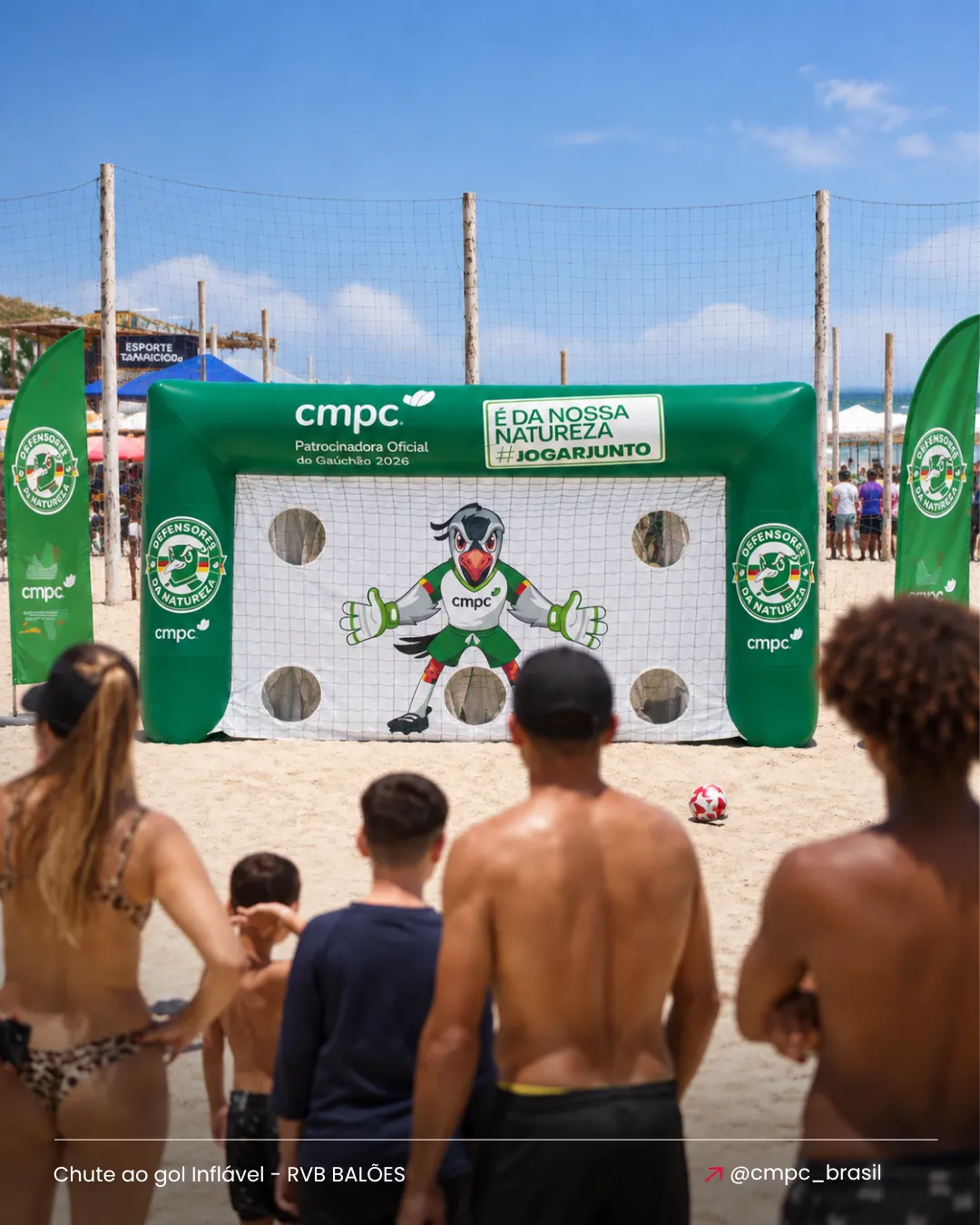 Chute ao gol inflável personalizado CMPC utilizado em ação esportiva com público na praia
