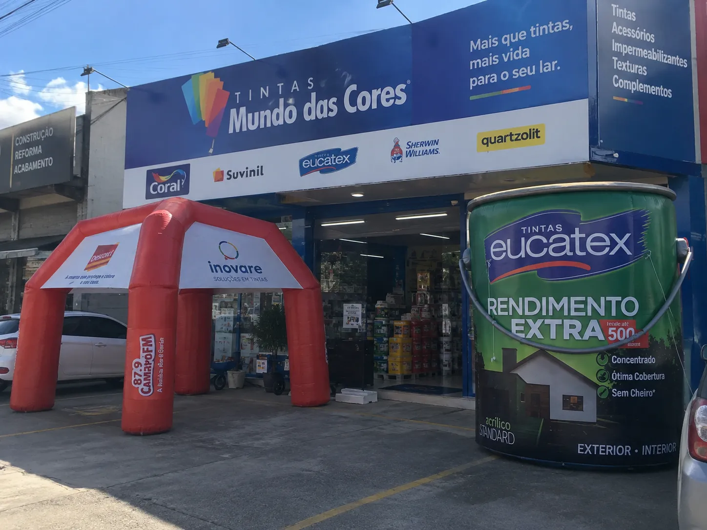 Fachada de loja de tintas transformada em showroom com tenda inflável e réplica gigante de lata Eucatex na entrada, fabricadas pela RVB Balões