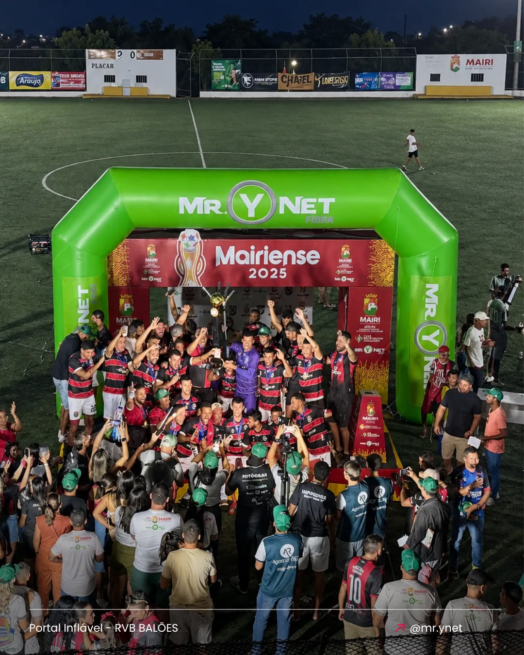 Portal inflável personalizado Mr. Y Net instalado em campo durante ação promocional com equipe