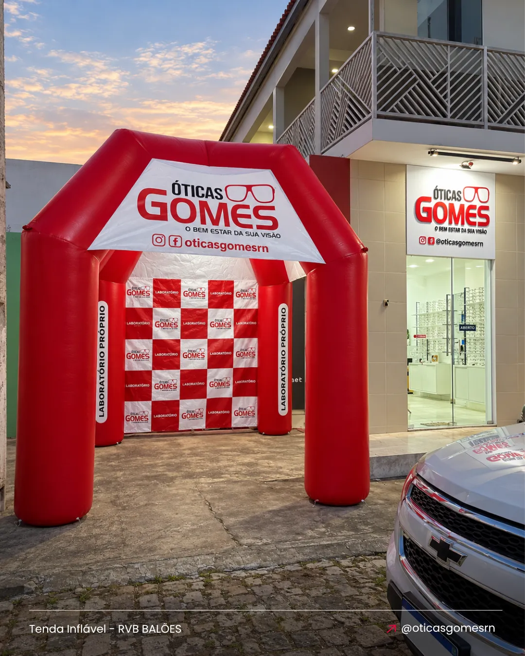 Tenda inflável personalizada Óticas Gomes instalada em frente à ótica para ação promocional